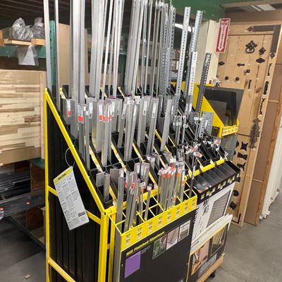 Sale Photo Thumbnail #72: Retail display rack filled with various lengths and profiles of mill finished aluminum extrusions and metal hardware.
