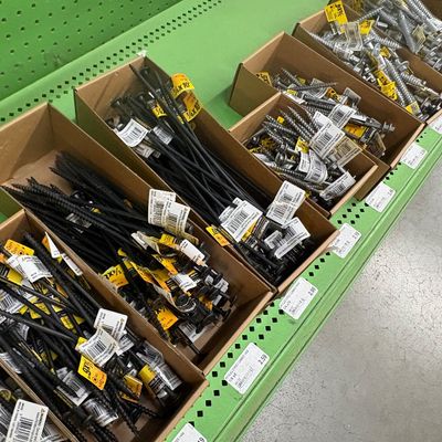 Sale Photo Thumbnail #23: Assorted PowerPro construction fasteners and lag screws organized in cardboard bins on a green retail display shelf.
