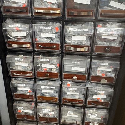 Sale Photo Thumbnail #22: Multi-drawer storage display unit filled with individually bagged cabinet handles and drawer pulls in various metallic finishes.