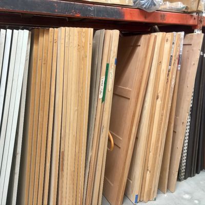 Sale Photo Thumbnail #54: Large assortment of interior wooden doors and panels stacked in a warehouse rack.