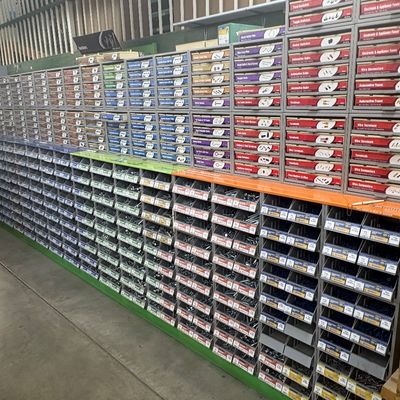 Sale Photo Thumbnail #64: Large multi-section commercial hardware organizer wall filled with labeled drawers and open bins of assorted screws, bolts, and fasteners.