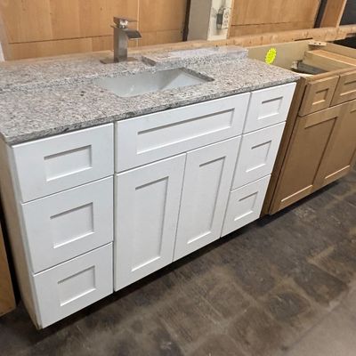 Sale Photo Thumbnail #82: Modern white Shaker-style bathroom vanity featuring a speckled granite countertop, an undermount rectangular sink, and a brushed nickel waterfall faucet.