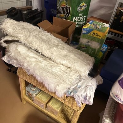 Sale Photo Thumbnail #23: Faux fur throws stacked on a two-tier wicker cart alongside paper products and household goods.