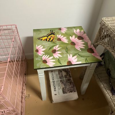 Sale Photo Thumbnail #18: Hand-painted small wooden accent table featuring a yellow swallowtail butterfly and pink coneflowers on a green background.