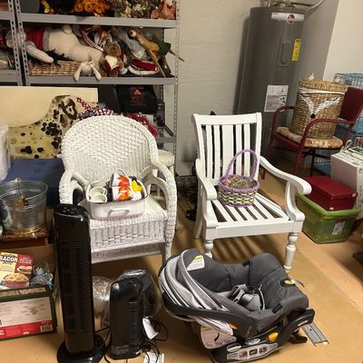 Sale Photo Thumbnail #25: Collection of household goods including a white wicker armchair, a white painted wooden slatted armchair, a Chicco infant car seat, space heaters, and seasonal decor.