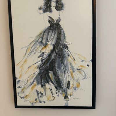 Sale Photo Thumbnail #53: Framed fashion illustration print depicting a woman in a sweeping black and gold gown, set in a slim black frame.