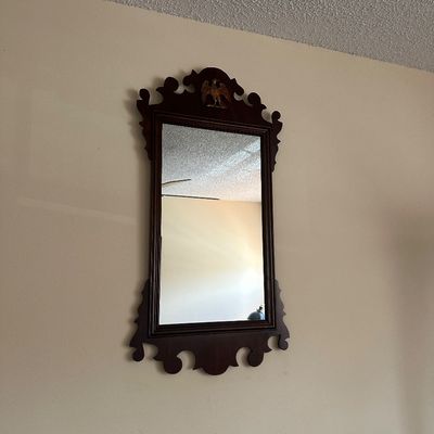 Sale Photo Thumbnail #69: Vintage Chippendale style wall mirror with dark wood scrollwork frame and a gold eagle motif at the crown.