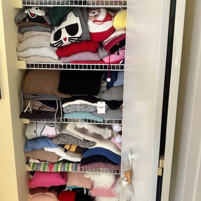 Sale Photo Thumbnail #67: Closet filled with wire shelving neatly stacked with various sweaters, knitwear, and holiday-themed garments.