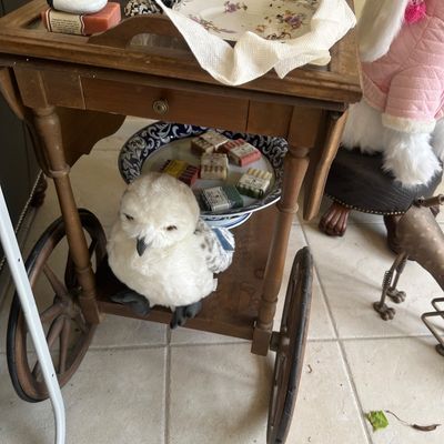 Sale Photo Thumbnail #5: Vintage wooden tea cart featuring drop leaves, large spoked wheels, and a drawer, holding decorative items and soaps.
