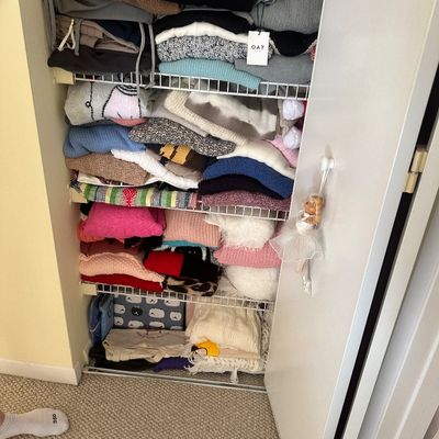 Sale Photo Thumbnail #66: Closet filled with neatly stacked sweaters, knits, and textiles arranged on wire shelving.