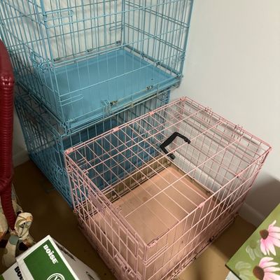 Sale Photo Thumbnail #17: Set of three wire pet crates, including two light blue crates stacked on the left and one pink crate on the right, each with carrying handles and removable plastic bottom trays.
