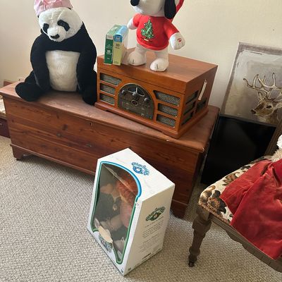 Sale Photo Thumbnail #74: Vintage-style tabletop turntable radio atop a wooden cedar chest, accompanied by a plush panda, holiday Snoopy doll, and a boxed Cabbage Patch Kids doll.
