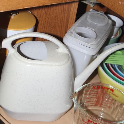 Sale Photo Thumbnail #68: Collection of vintage plastic kitchenware and a 4-cup glass Pyrex measuring cup arranged inside a wooden cabinet.