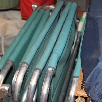 Sale Photo Thumbnail #130: Folded aluminum frame lawn chair with teal vinyl fabric stored in a garage or utility space.
