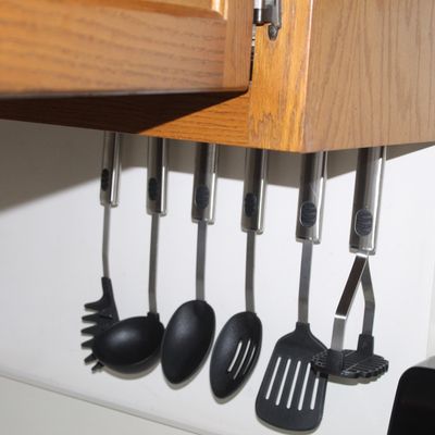 Sale Photo Thumbnail #56: Set of six modern stainless steel and black plastic cooking utensils mounted on an under-cabinet rack.
