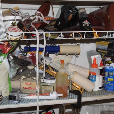 Sale Photo Thumbnail #132: A shelf filled with household utility items, including shoe polish, lint rollers, Elmer's Glue-All, mineral oil, and various hardware accessories.