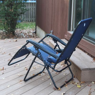 Sale Photo Thumbnail #32: Navy blue zero gravity reclining lawn chair with a black metal frame, set outdoors on a wooden deck.