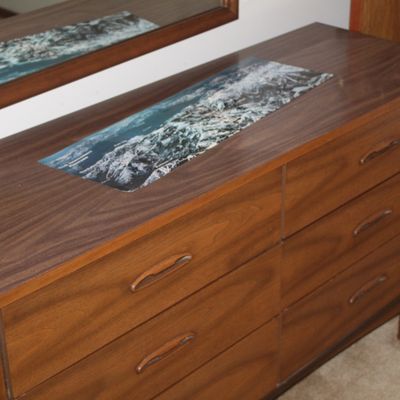 Sale Photo Thumbnail #9: Mid-century modern walnut six-drawer dresser with sculpted wooden handles and matching wall mirror.