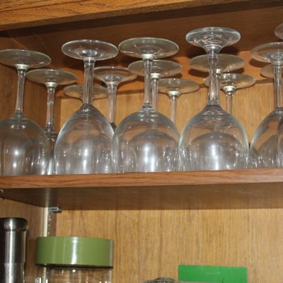 Sale Photo Thumbnail #58: Collection of clear glass stemware stored upside down inside a oak wooden cabinet.