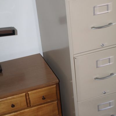 Sale Photo Thumbnail #15: Tall beige four-drawer metal filing cabinet positioned next to a traditional wooden dresser.