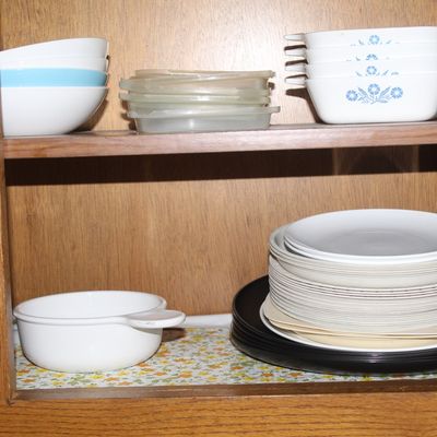 Sale Photo Thumbnail #55: Collection of vintage CorningWare, Pyrex, and white dinnerware neatly arranged inside a wooden cabinet.