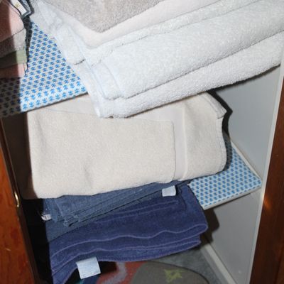 Sale Photo Thumbnail #12: Linen closet filled with stacked bath towels, washcloths, and hand towels in various colors including pink, white, cream, and blue.