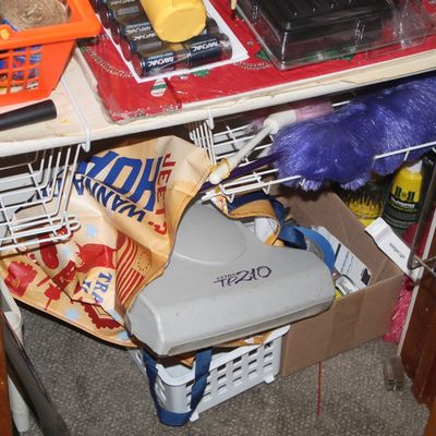Sale Photo Thumbnail #135: Assorted household supplies stored in a wire shelving unit, including Rayovac D batteries, duster heads, an Ultra TP210 vacuum head, and shopping bags.