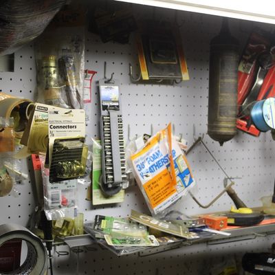 Sale Photo Thumbnail #96: Workshop pegboard organized with various hardware items, including duct tape, weatherstripping, electrical connectors, socket sets, and hand tools.
