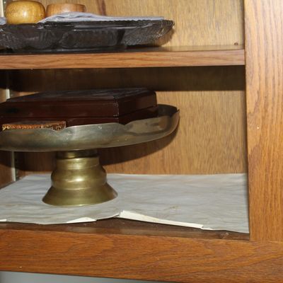 Sale Photo Thumbnail #50: Brass pedestal cake stand holding a polished wooden jewelry box, displayed inside an oak cabinet alongside glass and wooden accent pieces.