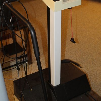 Sale Photo Thumbnail #83: Vintage Precor motorized treadmill featuring a central control console with speed adjustment buttons and black handrails.