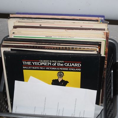Sale Photo Thumbnail #109: Collection of vintage vinyl LP records stored in a gray plastic basket, featuring classical and theatrical titles like Gilbert & Sullivan's The Yeomen of the Guard.