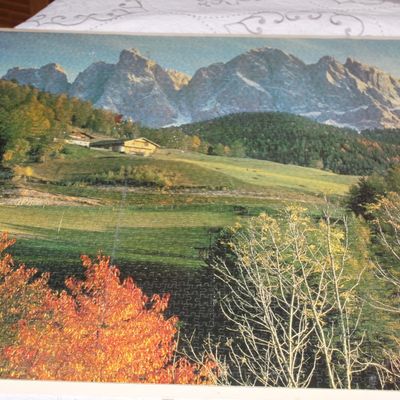 Sale Photo Thumbnail #17: Completed jigsaw puzzle depicting a scenic Alpine mountain landscape with rolling green hills and autumn foliage.