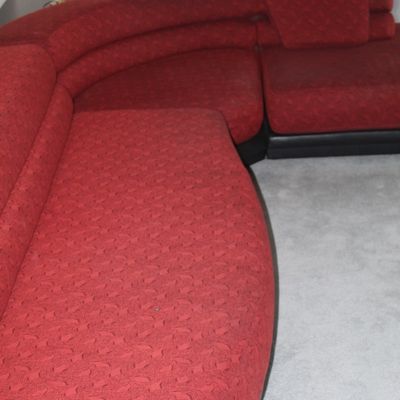 Sale Photo Thumbnail #21: Vintage curved sectional sofa in patterned red upholstery with a dark trim base.