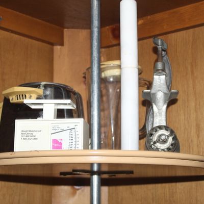 Sale Photo Thumbnail #62: Collection of vintage kitchen items on a lazy Susan shelf, including a metal meat grinder, a glass blender pitcher, and a Weight Watchers food scale.