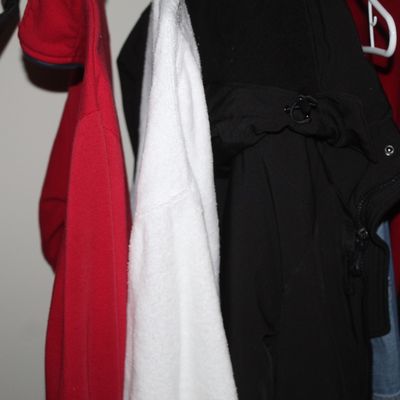 Sale Photo Thumbnail #6: Selection of outerwear hanging in a closet, including a red fleece pullover, a white towel cloth garment, and a black jacket.
