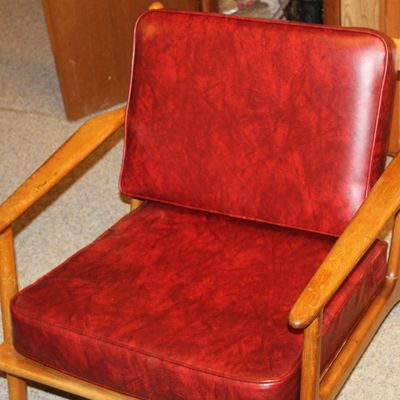 Sale Photo Thumbnail #124: Mid-century modern armchair featuring a light wood frame and mottled red vinyl cushions.