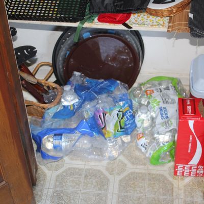 Sale Photo Thumbnail #46: Pantry closet filled with bottled water, soda, serving trays, and various household organization items.