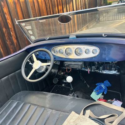 Sale Photo Thumbnail #24: Custom hot rod interior featuring a blue dash, engine-turned gauge cluster insert, three-spoke Ford steering wheel, and black leatherette bench seat.