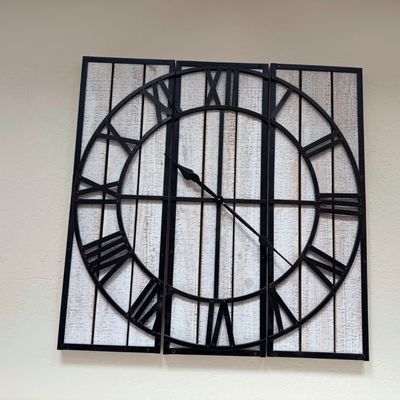 Sale Photo Thumbnail #8: Large rustic modern three-panel wall clock featuring a black wrought iron metal frame with Roman numerals over a distressed whitewashed wood backing.
