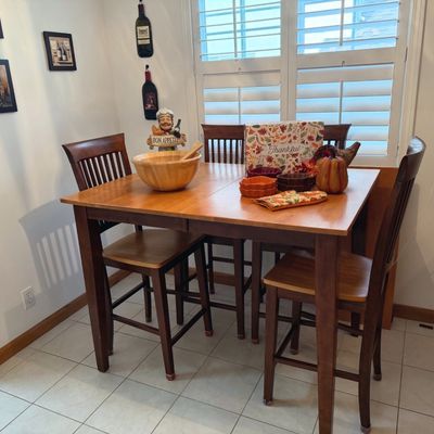 Sale Photo Thumbnail #56: Contemporary pub-height dining table with four slat-back barstools, displayed with various tabletop decor and autumn-themed servingware.