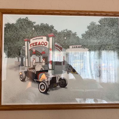 Sale Photo Thumbnail #4: Framed vintage art print depicting a hot rod parked outside a classic Paradise Texaco gas station, mounted in a light wood frame.