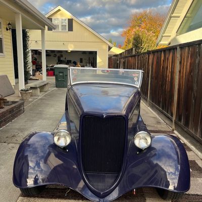Sale Photo Thumbnail #22: Vintage 1930s-style hot rod roadster finished in glossy deep purple, parked in a residential driveway.