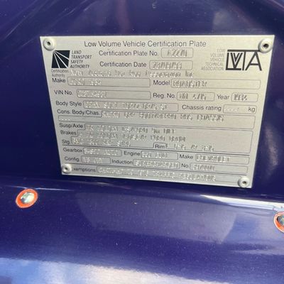 Sale Photo Thumbnail #31: Low Volume Vehicle Certification Plate attached to a dark blue painted body, detailing build specs for a 1934 Ford Roadster.