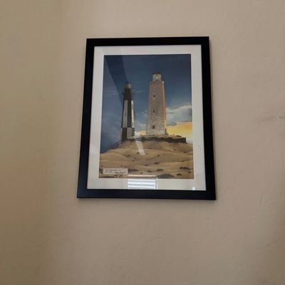 Sale Photo Thumbnail #15: Framed lighthouse print depicting the Cape Henry Light, presented in a black frame with white matting.