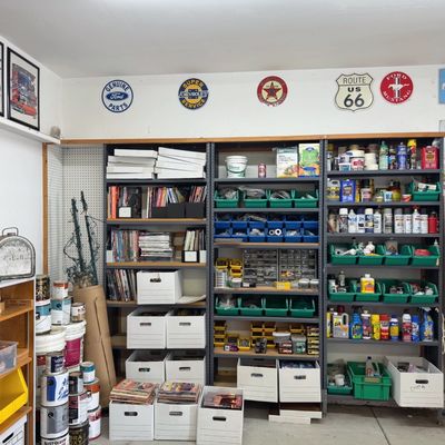 Sale Photo Thumbnail #39: Workshop storage filled with automotive signs, art prints, supplies, hardware organizers, paint cans, and various vintage radio equipment.