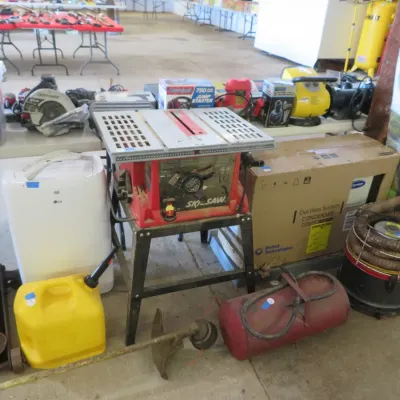 Sale Photo Thumbnail #42: Skilsaw table saw on a metal stand surrounded by various tools, power equipment, an LG dehumidifier, and garage supplies.