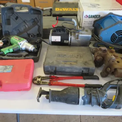 Sale Photo Thumbnail #31: Assortment of power and hand tools, including a reciprocating saw, bolt cutters, green impact wrench in case, vacuum pump, and Craftsman tool cases.