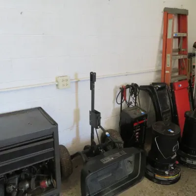 Sale Photo Thumbnail #24: Collection of workshop equipment including a metal rolling tool chest, portable space heaters, battery charger, mechanics creeper, and stepladders.