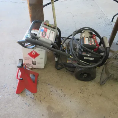 Sale Photo Thumbnail #38: Gas-powered pressure washer on a wheeled frame alongside a red jack stand and a metal floor fan.