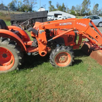 Sale Photo Thumbnail #66: Orange Kubota HST tractor equipped with a LA525 front loader attachment, showing light wear from use.